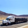 White plastic fabric solutions flatbed trailer depicting the use of a 8 ft drop lumber tarp