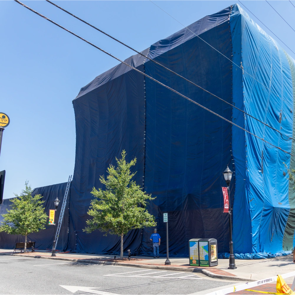 Building covered in blue fumigation tarp depicting the use of 8oz PVC coated polyester fabric