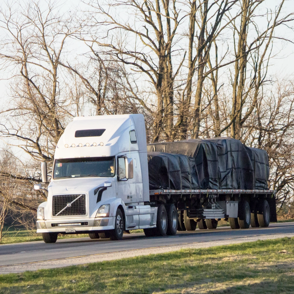 Picture of a white flatbed trailer showing the application of 22oz PVC coated polyester fabric