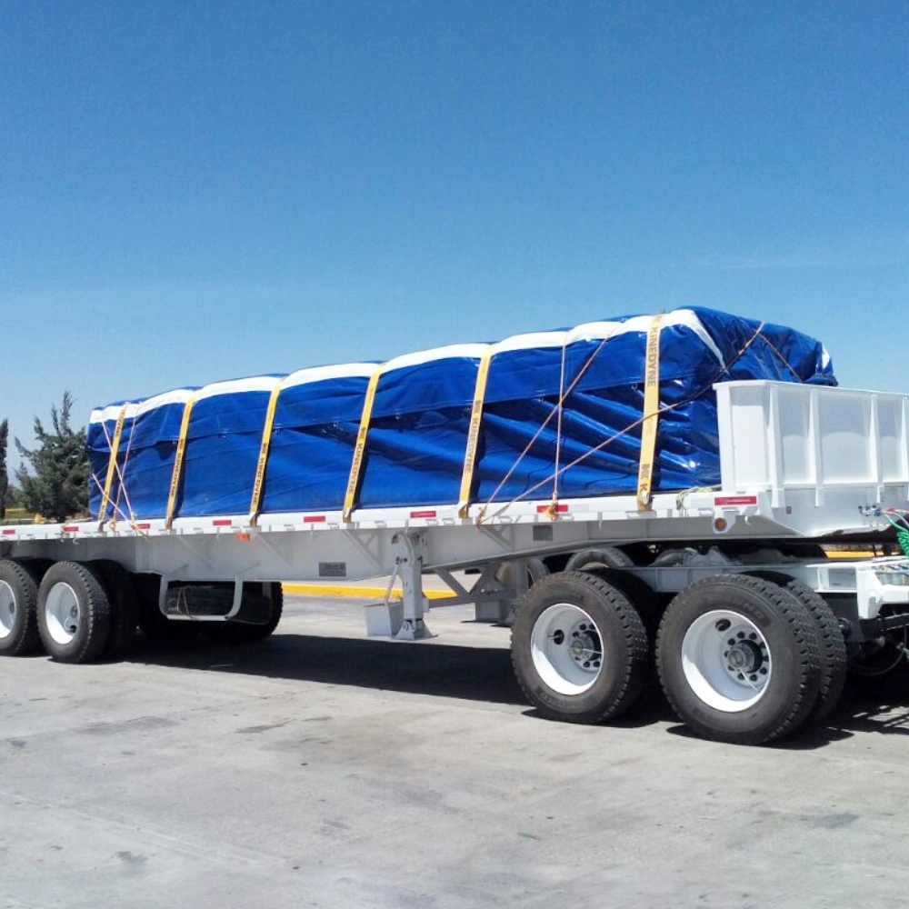 Picture of blue steel tarp covering a load on a flatbed depicting the use of 24oz PVC coated polyester fabric