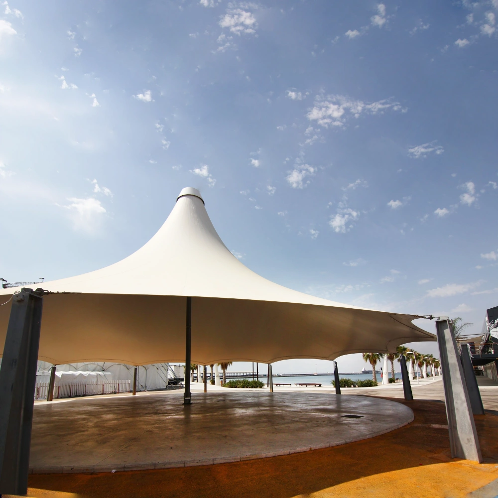 Picture of a white structured shade next to the beach depicting application of 24oz PVC coated polyester fabric
